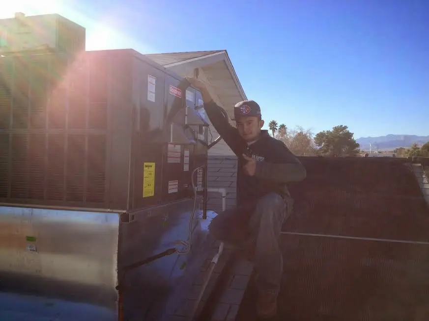HVAC technician performing Air Duct Cleaning on a rooftop unit in St. Louis